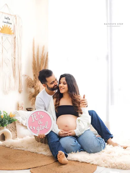 A happy and bright couple's portrait announcing their baby girl. The Boho setup with its natural textures provides a perfect, relaxed backdrop.