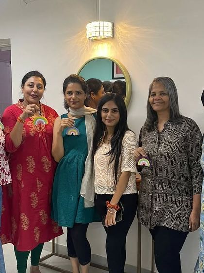 A group of ladies showing off their handmade rainbow charms, a symbol of a creative afternoon spent together.