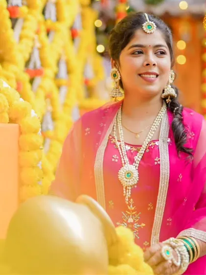This beautiful mom-to-be is celebrating her baby shower in a lovely pink outfit. Her white and green floral jewellery set provides a stunning contrast and an elegant touch.