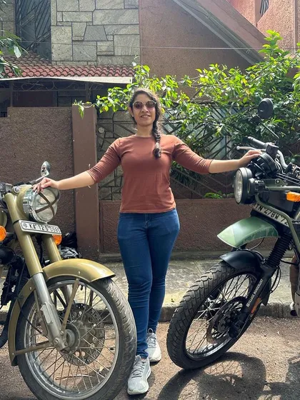 Standing confidently between two powerful machines. This rider has completed her training and is ready for whatever the road ahead holds.