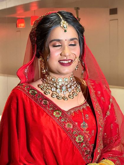 A happy bride in a classic red velvet lehenga. The rich fabric and heavy jewellery make this a perfect rental for a winter wedding.