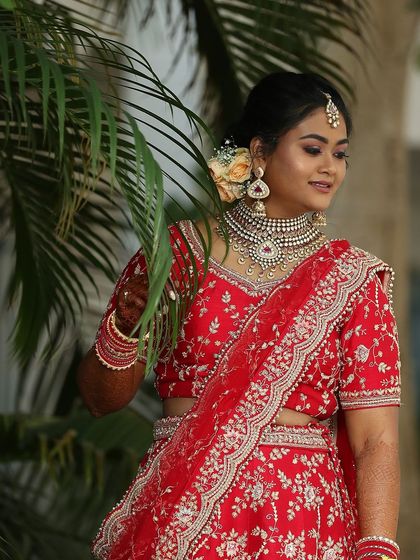 Akanksha's beautiful reception look. The makeup features a soft smokey eye and a neutral lip, allowing her stunning red lehenga and bridal jewellery to stand out.