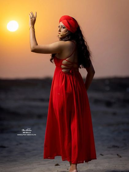 A beautiful silhouette shot against the setting sun, showcasing the back of the red dress and the overall mood of the conceptual shoot.