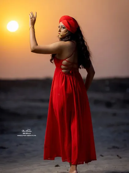 A beautiful silhouette shot against the setting sun, showcasing the back of the red dress and the overall mood of the conceptual shoot.