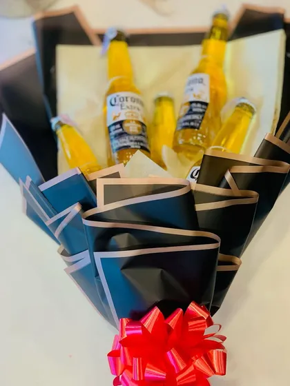 Another angle of the Corona beer bouquet, showing the sleek black wrapping with rose gold trim and a bright red bow.