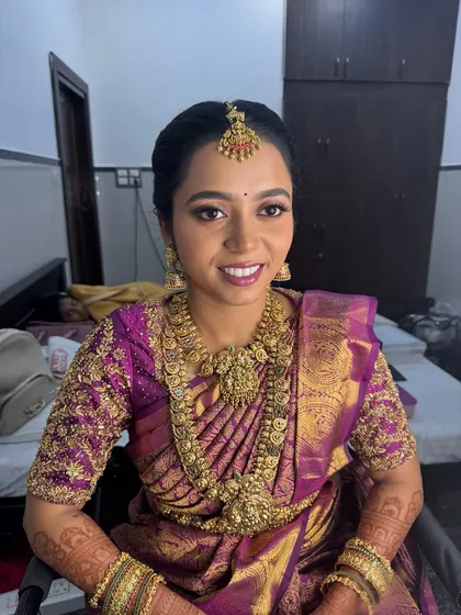 A happy and radiant portrait of my bride Anitha. Her smile lights up the frame, showcasing her flawless Muhurtham makeup, including the well-blended foundation and the beautiful lip colour that matches her saree.