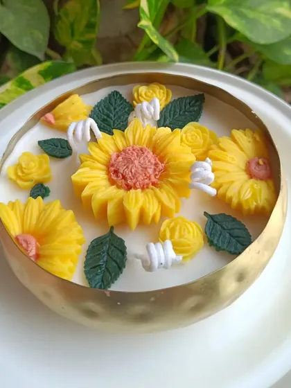 This sunflower-themed urli candle is perfect for adding a bright and cheerful touch to your home. The golden hammered brass bowl is filled with yellow sunflower and rose embeds, creating a vibrant floral display.
