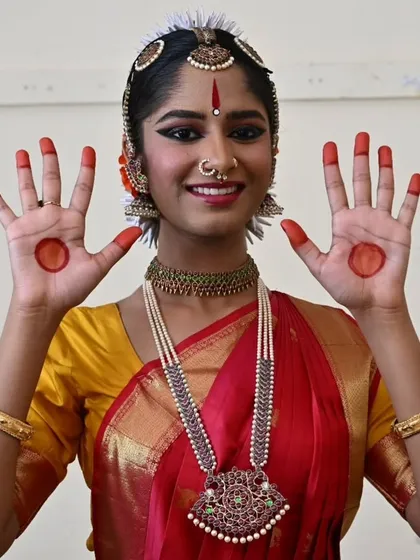 Anvita proudly displays her hands adorned with alta, the traditional red dye. This is an integral part of the dancer's makeup, highlighting the expressive hand gestures, or hastas.