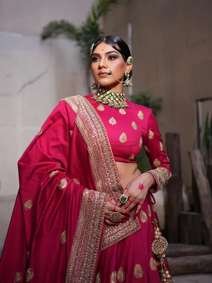 A full-length view of the pink lehenga. The styling highlights the rich color and the elegant drape of the dupatta.