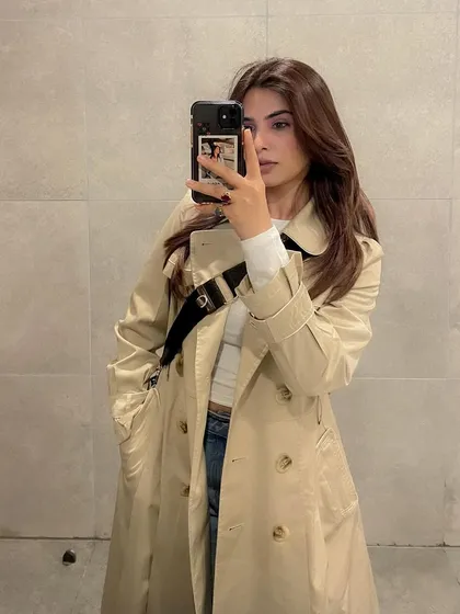 A classic mirror selfie showcasing a timeless trench coat. This type of shot is great for showing off outerwear in a way that feels personal and is a staple of fashion UGC.