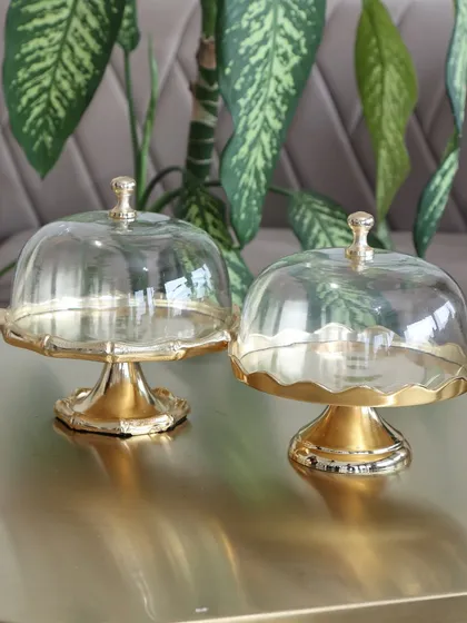 Our collection of gold dessert stands with glass cloches, including the classic bamboo-style and the scalloped design. Each is crafted to elevate your desserts with a touch of luxury.