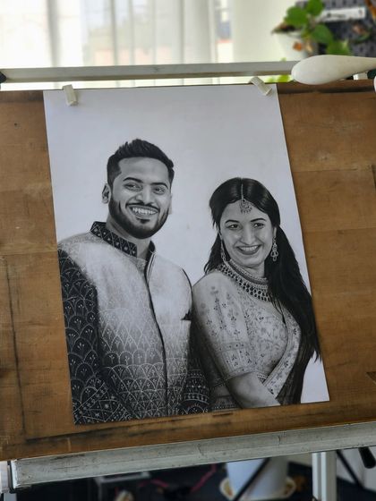 The finished A2 size portrait on my drawing board, showcasing the intricate patterns on their traditional attire.
