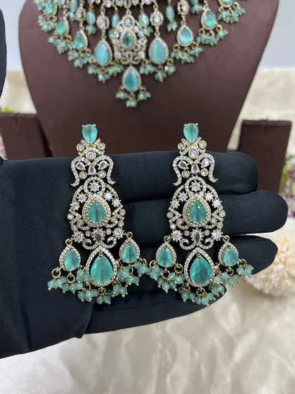 A close-up of the earrings from the green AD zircon choker set, showing the fine detailing.