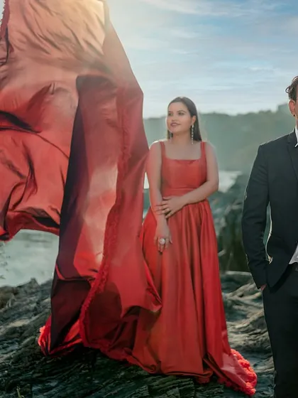A powerful, stylish pose against the river. This shot highlights the couple's confidence and the striking silhouette of the red gown, creating a modern and fashionable pre-wedding photograph.