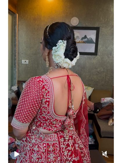 A slightly different angle of the classic white floral bun, showing the full breadth of the arrangement. This style provides excellent support for a heavy bridal dupatta.