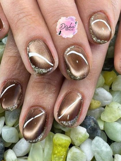 Bronzed beauty with a touch of sparkle. This cat eye design in a warm bronze tone is accented with a silver glitter tip and a clean white line.