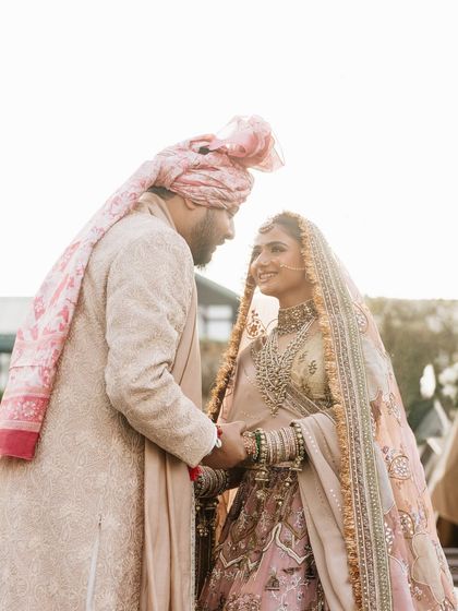 A beautiful, intimate moment between the happy couple. Vasav's soft bridal makeup looks perfect against her groom's coordinating pastel outfit.