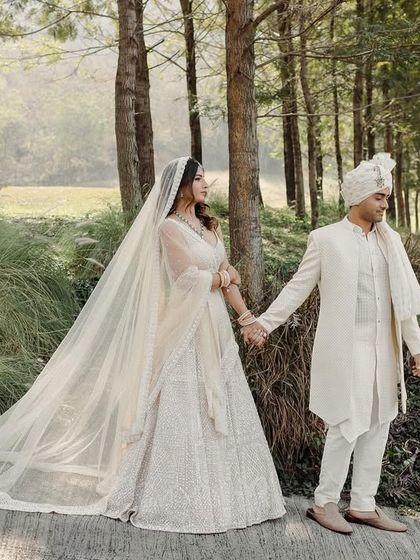 A fairytale moment in the woods. The bride's long veil trails behind her as they walk hand-in-hand, creating a sense of timeless romance. I use natural landscapes to frame your love story, making it feel both grand and intimate.