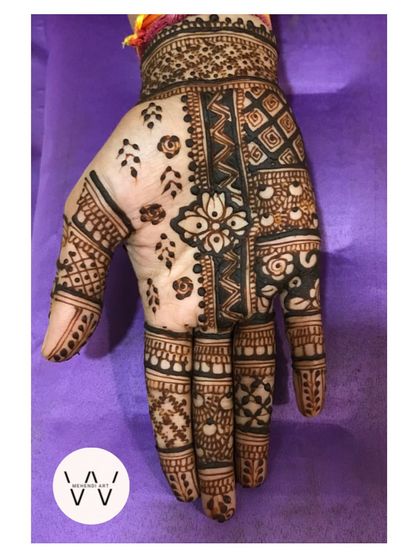 A close-up of the hand with the intricate patchwork design.