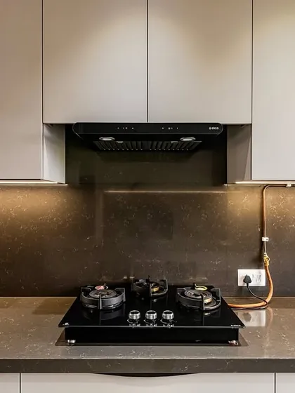 A close-up of the hob and chimney area, highlighting the clean installation and modern appliances.