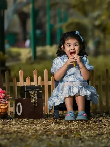 A fun outdoor milestone shoot celebrating a third birthday. The rustic props and natural environment create a playful and memorable setting.