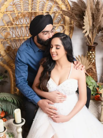 A loving kiss on the forehead. This sweet moment between the parents-to-be is perfectly captured in our warm and rustic peacock chair setting.