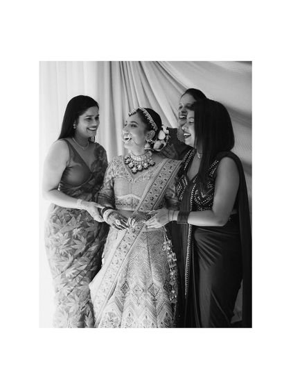 A moment of shared laughter between the bride and her bridesmaids. This black and white shot captures the joy and support system that surrounds a bride on her big day.