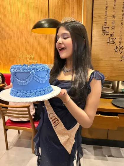 A beautiful young lady celebrating her birthday with a custom vintage style cake. The delicate blue piping and draping details were designed to match her elegant party dress.