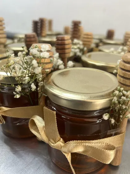 A tiny detail from my housewarming favors. These small jars of honey, adorned with baby's breath and a golden ribbon, add a touch of simple elegance.