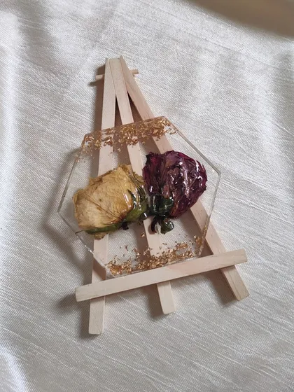 This hexagonal coaster showcases two beautifully preserved rosebuds, one yellow and one deep red. I added a sprinkle of gold flakes to complement the natural colors of the flowers.