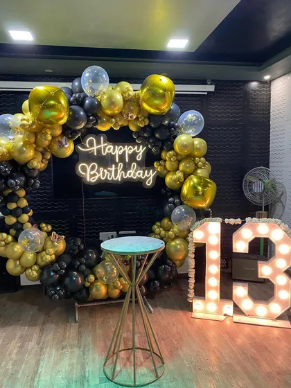 A bold black and gold ring decoration for a 13th birthday, marking the transition to the teenage years with a cool, modern vibe.