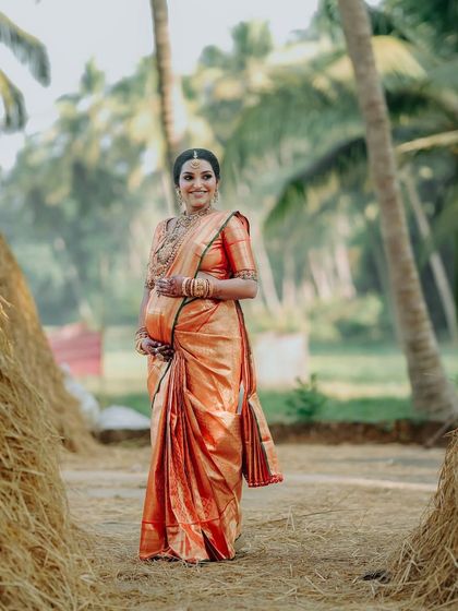 Our client Rashmi, celebrating the beautiful chapter of motherhood in a pleasant red silk saree. This baby shower look is all about grace, tradition, and that goddess glow.
