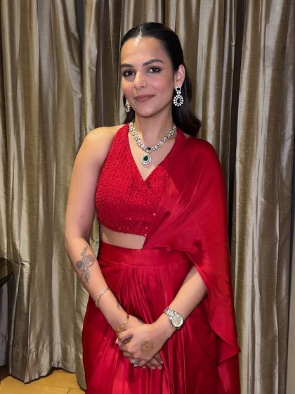 The client looks stunning in her red outfit, her hair styled in glamorous waves.