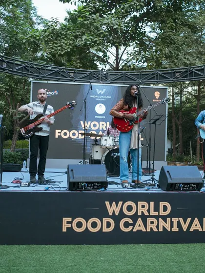 A full stage view of a band performing at the World Food Carnival. The live music is a key part of the experience, creating a perfect backdrop for a day of food and fun.
