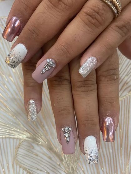 This mismatched set is all about glamour, combining chrome, glitter, and nude nails with a bold rhinestone accent nail.