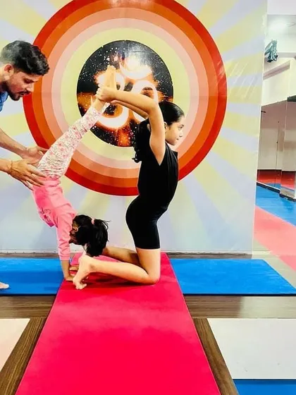 With a little help from an instructor, these two young students create a beautiful and challenging partner pose. We guide them every step of the way.