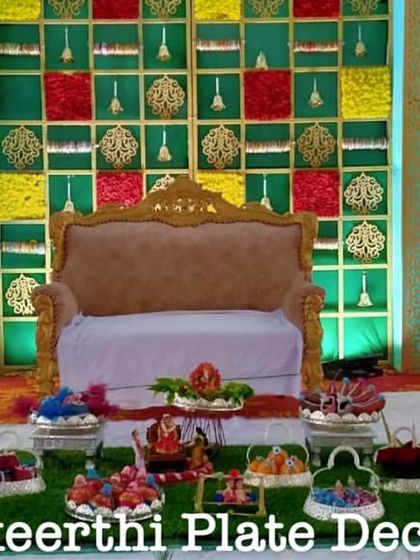 A full view of a baby shower plate decoration display in Perundurai. The setup includes a variety of seer varisai items arranged in front of the main stage.