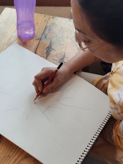 Learning one-point perspective. This student is practicing how to create the illusion of depth on a flat surface, a core skill for drawing landscapes and interiors.