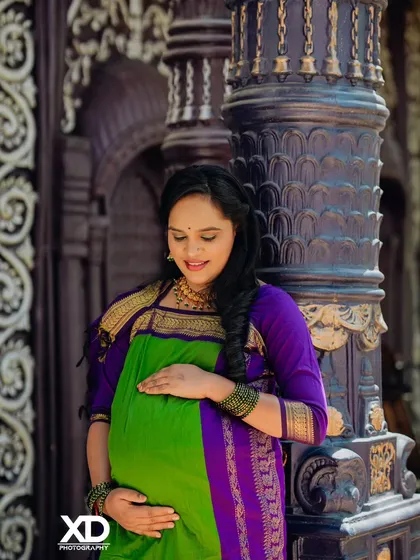 A quiet moment of connection. This solo portrait of the mother-to-be in a traditional Nauvari saree highlights the serene beauty and strength of pregnancy against a backdrop of classic architecture.