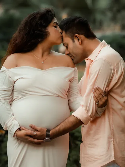 An intimate and emotional portrait from a maternity shoot. The gentle kiss on the forehead and the protective embrace perfectly capture the love for their unborn child.