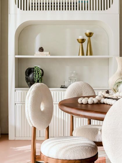 A close-up of the dining chairs and bar unit, showcasing the soft, cloud-like upholstery and elegant, fluted details.