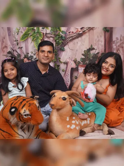 A lovely family portrait taken within our Jungle Safari studio setup. The scene is filled with plush tigers and deer, along with a lush, illustrated jungle backdrop for a complete family photo.