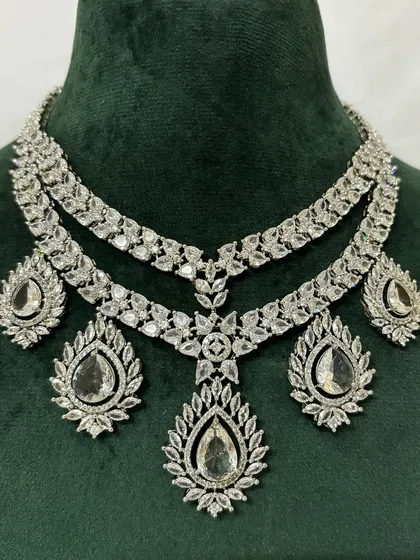 For a modern reception or cocktail party, this layered American diamond necklace set is available for rent. The brilliant-cut stones provide a dazzling look, and the set includes matching drop earrings.