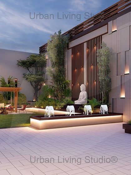 A wider view of the Aligarh front lawn design. The layout includes multiple seating areas, a large water feature with fountains, and a variety of trees and plants, all tied together with elegant wall lighting.