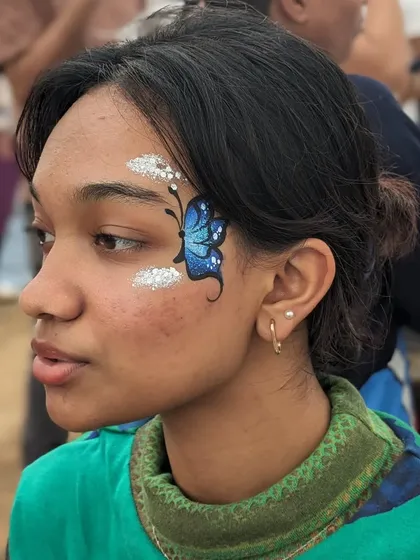 A blue butterfly design taking flight from a cloud of silver glitter.