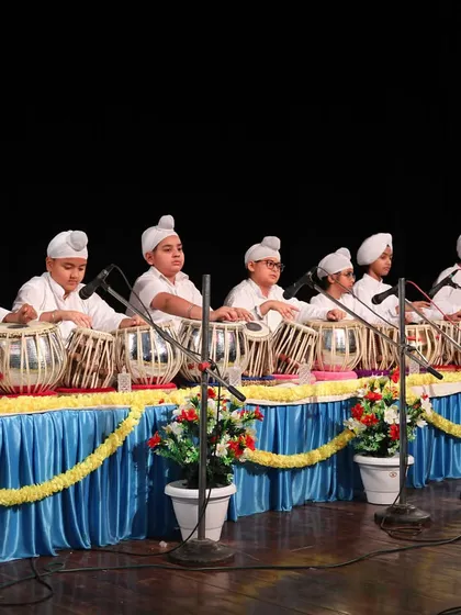 A wide view of our tabla students during a grand stage performance. Group performances are a cornerstone of our academy, fostering teamwork and a deep understanding of rhythmic coordination.