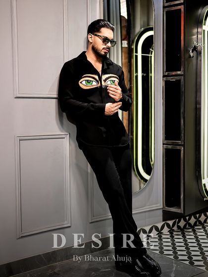 Leaning with a relaxed confidence, this shot showcases the provocative and unique design of the 'Haters' eyes shirt.