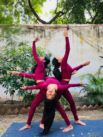 A beautiful three-person yoga pose creating a 'Triveni' or confluence, symbolizing unity and balance.