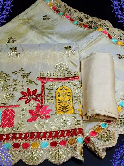 A festive unstitched dress material with beautiful, colorful embroidery depicting a traditional scene. The dupatta has a lovely scalloped border with multi-colored details, making it a truly unique piece.