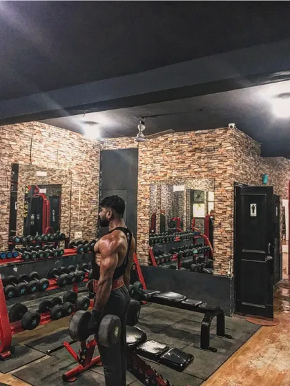 A side view of my physique, showing shoulder and back development.
